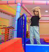 A baby girl standing on slide