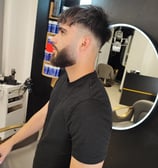 a man in a black shirt is standing in front of a mirror