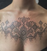 An handpoke tattoo featuring art ornaments tappis geomatric symmatrical lines inspired, 