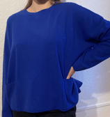Une femme qui porte un pull bleu