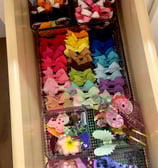 an organized drawer full of colorful hair clips