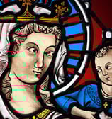 a stained glass window with a painting of a woman
