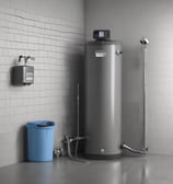 A plastic bag is filled with a coarse white substance, likely sea salt. The bag has a label featuring text and a small drawing. Other similar bags are piled in the background, suggesting a market or store setting.