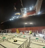 a large ship in the water with a man standing on the deck