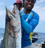 a man holding a fish on a boat