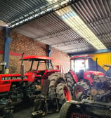 a tractor with a man standing in a garage