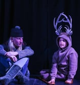 Two youth actors in costumes on stage performing Frozen Jr.