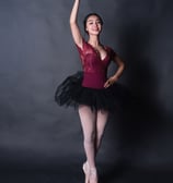 Teen ballerina in a red leotard and ballet shoes