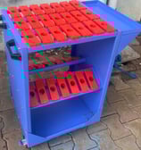 A blue tool trolley with red plastic tool pockets