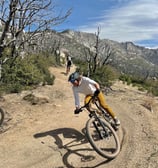 a man riding a bike on a dirt road