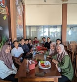 a group of people sitting at a table with food