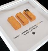 white frame with gold bars and motivational sentence