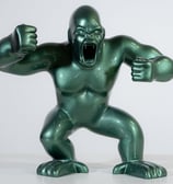 a green statue of a gorilla with a fist fist