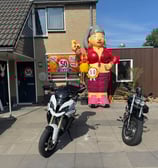 Opblaas pop Sarah gekleed in het rood aan de voorkant van een huis