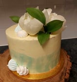 a cake with white flowers on top of a wooden board