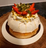 a cake with fruit on top of a wooden board