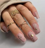 a woman's hand painted nails with gold foil and glitter
