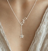 a woman wearing a necklace with a starfish charm