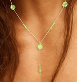 a woman wearing a necklace with green beads and a necklace