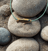 a small goldfish on a rock with a green cord cord cord