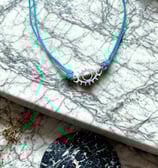 a necklace with a blue cord cord cord cord cord and a necklace with a silver