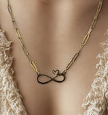 a woman wearing a necklace with a infinity symbol