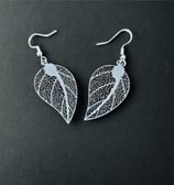 a pair of earrings with a leaf design