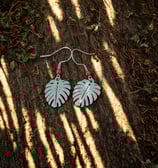 a pair of earrings with a leafy design