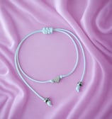 a pair of earphones with a white cord cord and a pink ribbon