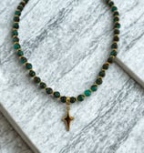 a necklace with a gold starfish charm on a marbled surface