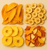 Flat lay of four dried fruit varieties: mango slices, banana chips, pineapple rings, and assorted dr