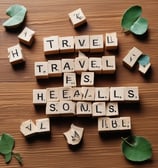 Wooden Scrabble tiles spell out the words 'Make Memories' on a textured wooden surface.