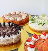 a variety of cakes on plates with strawberries