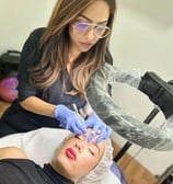 a woman getting her eyebrows done by a professional hairdresser