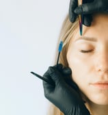 a woman with a tattoo on her forehead and hands in black gloves