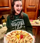 Smiling woman holding a party platter of little smokies in Smoky Lil Buns