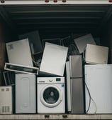 A box truck filled with old appliances to be disposed of.