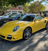 a yellow porsche 9115 parked in a parking lot