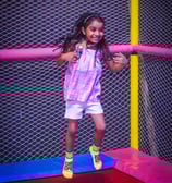 a young girl is playing with a baseball bat