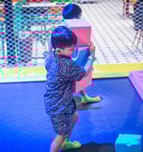 a young boy playing with blocks on a trampoline