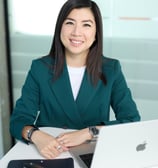 a woman in a green jacket and a laptop