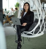 a woman sitting in a chair with a laptop on her lap