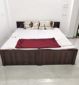 a bed with a red blanket and pillows