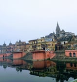 a river with a bridge and buildings in the background