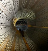 a man standing in a metal structure with a large metal structure