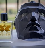 a mask mask and a perfume bottle on a table