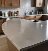 A man is painting on a wall, wearing a white shirt with red stripes and a hat. He is using a small brush on a piece of taped paper, creating an artwork that appears to depict a tree. The wall is beige and features architectural molding.