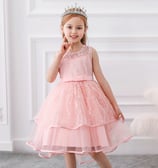 a little girl wearing a tiara and a beautiful peachy pink party dress