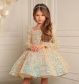 a young girl in a sparkly gold party dress