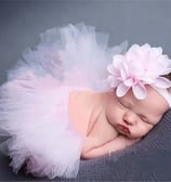 a baby girl sleeping in a pink tutu with a matching headband